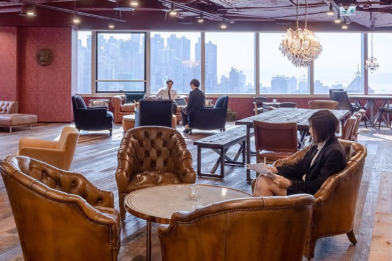 Professionals sitting at lounge area in a coworking space for client meetup
